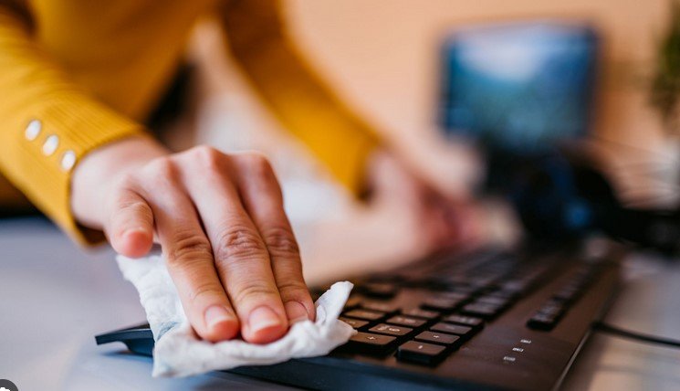 woman cleaning a keyboard